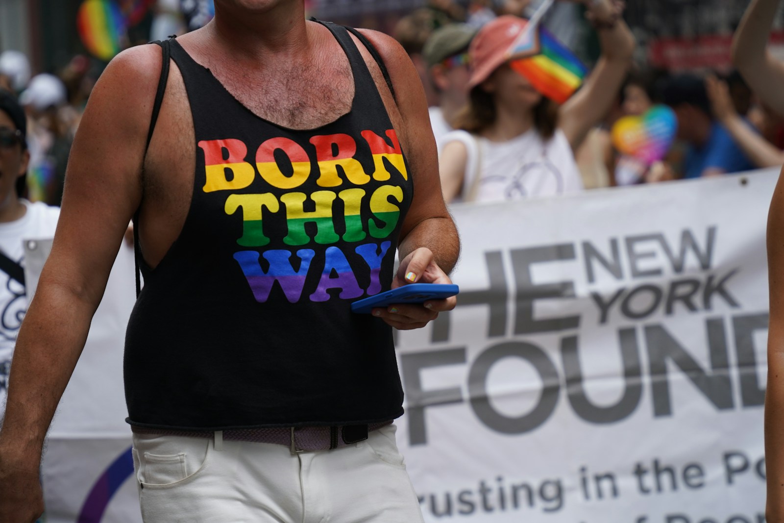 A man in a gay pride t - shirt walking down the street